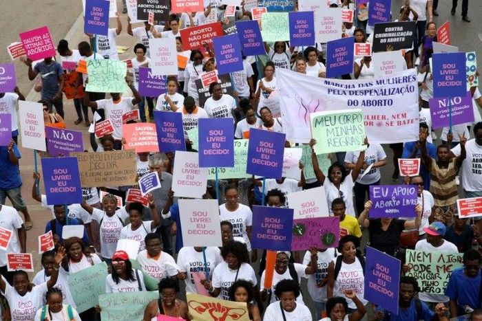 Hundreds of Angolans hold placards and shout slogans as they march to protest against a draft law that would criminalise all abortions