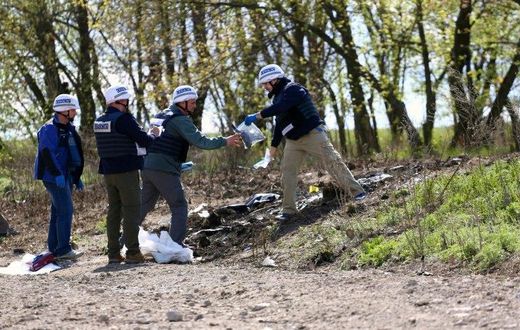 OSCE monitors work near Lugansk on April 25, 2017, to inspect the site where an OSCE patrol vehicle was destroyed by an explosion on April 23