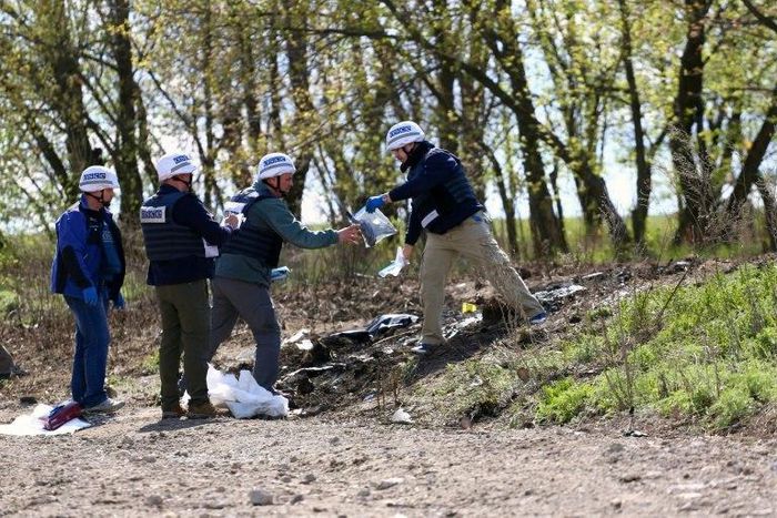 OSCE monitors work near Lugansk on April 25, 2017, to inspect the site where an OSCE patrol vehicle was destroyed by an explosion on April 23