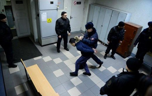 A police officer escorts a man suspected of involvement in the Saint Petersburg metro bombing inside a court building in Saint Petersburg on April 7, 2017