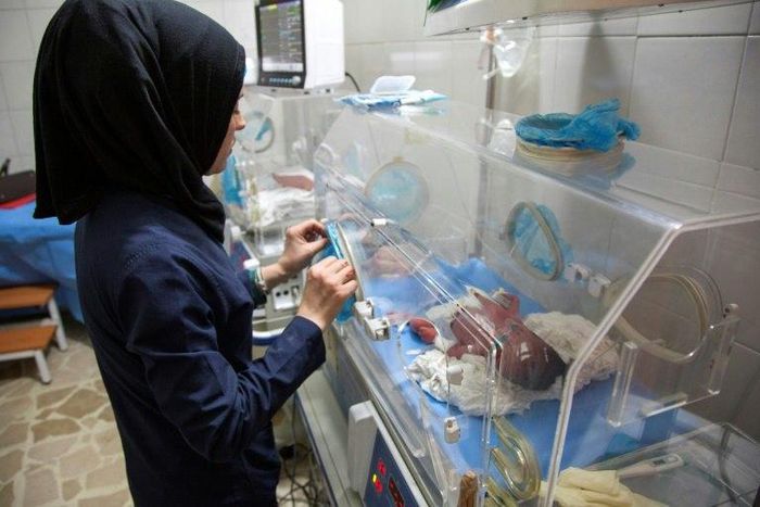 This file picture shows a Syrian nurse standing next to incubators with newborns at a children's hospital on June 9, 2016