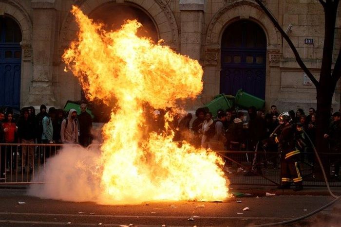 French firefighters try to extinguish a burning barricade as students gather during a demonstration outside the "Lycee Voltaire" secondary school in Paris, on February 23, 2017