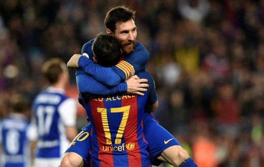 Barcelona's Paco Alcacer (bottom) celebrates with teammate Lionel Messi during their match against Real Sociedad at the Camp Nou stadium in Barcelona on April 15, 2017
