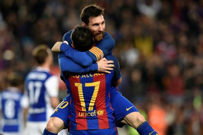 Barcelona's Paco Alcacer (bottom) celebrates with teammate Lionel Messi during their match against Real Sociedad at the Camp Nou stadium in Barcelona on April 15, 2017