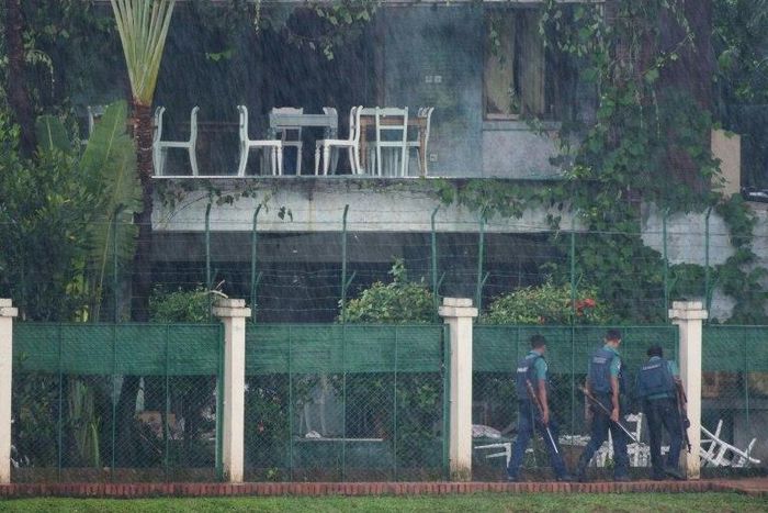 Policemen check the back garden of an upscale cafe in Dhaka on July 3, 2016 a day after a bloody siege ended with the death of 22 hostages, including 18 foreigners