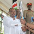 President Uhuru Kenyatta receiving the Queen's Baton Relay symbol