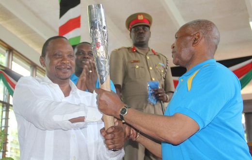President Uhuru Kenyatta receiving the Queen's Baton Relay symbol