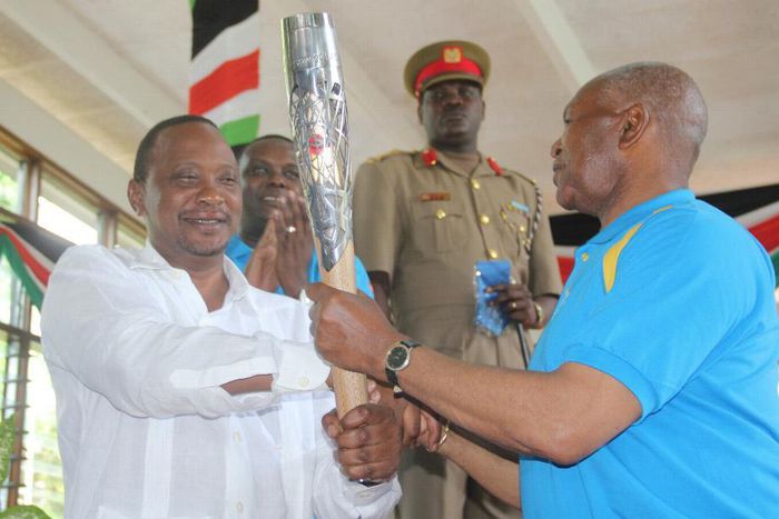 President Uhuru Kenyatta receiving the Queen's Baton Relay symbol