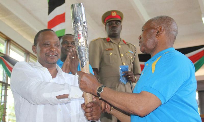 President Uhuru Kenyatta receiving the Queen's Baton Relay symbol
