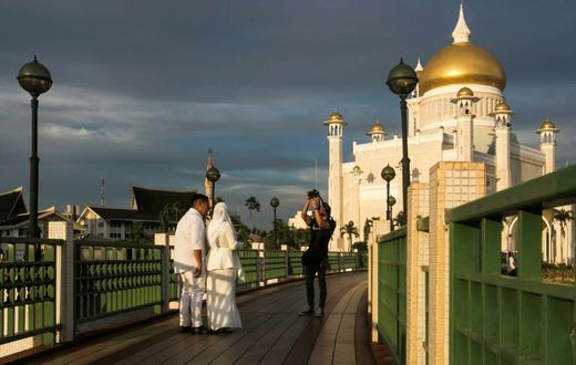 Newlyweds have their photographs taken at the Sultan Omar Ali Saifuddien mosque in Brunei's capital Bandar Seri Begawan