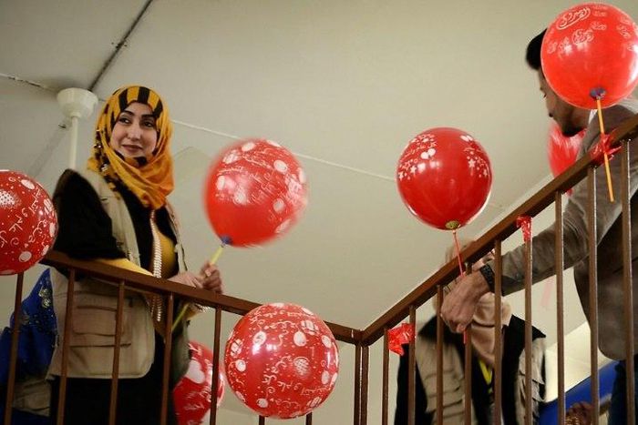 A member from the "Rebirth Generation", a group of Iraqi youths who are trying to revive the embattled city of Mosul, distributes balloons as they organise an event to mark Valentine's Day on February 14, 2017