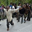Migrants celebrate after forcing their way through a fence between Morocco and the tiny Spanish enclave of Ceuta, on February 17, 2017