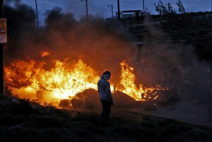 Jewish settlers set tyres ablaze at the Amona outpost, northeast of Ramallah, on February 1, 2017
