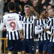 Millwall's Shaun Cummings (R) celebrates with teammates after scoring their only goal against Leicester City at The Den in south London on February 18, 2017