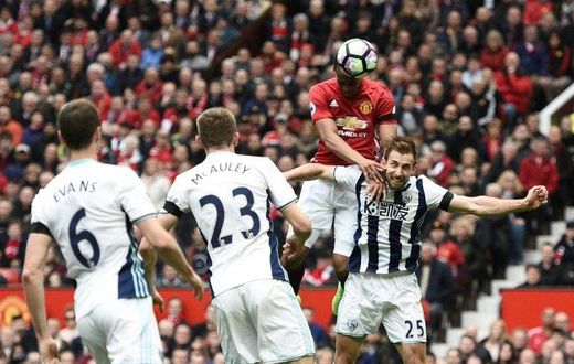 Manchester United's Anthony Martial (2R) climbs above West Bromwich Albion's Craig Dawson (R) but heads wide during their match at Old Trafford on April 1, 2017