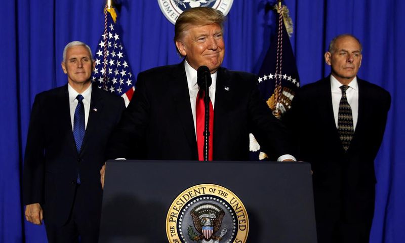 President Donald Trump (C), flanked by Vice President Mike Pence (L) and Homeland Security Secretary John Kelly (R), delivers remarks at Homeland Security headquarters on January 25, 2017.
