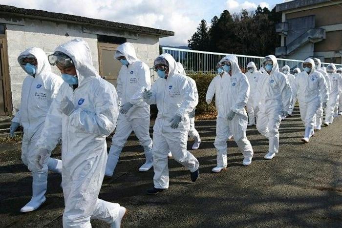 Wearing anti-virus suits, soldiers of Japan's Ground Self Defense Force head to a chicken farm in Sekikawa, Niigata prefecture, on November 29, 2016