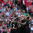 Liverpool players celebrate their first goal scored by midfielder Philippe Coutinho against Arsenal on August 14, 2016