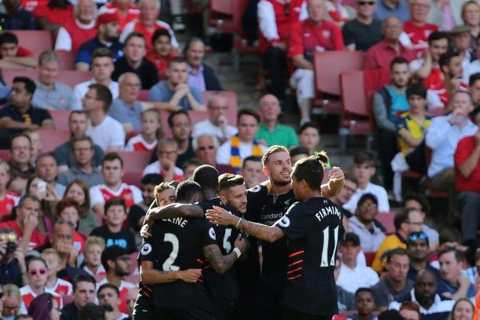 Liverpool players celebrate their first goal scored by midfielder Philippe Coutinho against Arsenal on August 14, 2016