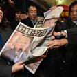 A woman in Tokyo gives out extra editions of a newpaper reporting the victory of Donald Trump in the US presidential election