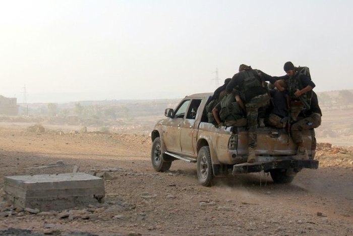 Fighters from Fateh al-Sham Front advance on a road south of Aleppo on August 6, 2016