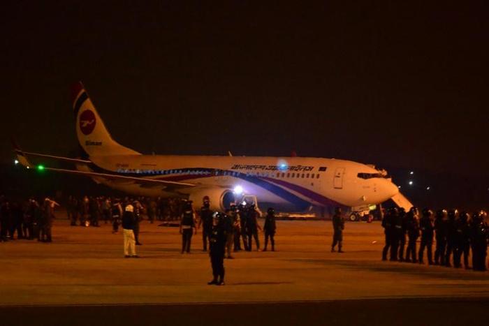 Bangladeshi security personnel stand guard near the hijacked Dubai-bound plane. Officials say the would-be hijacker was carrying a toy gun