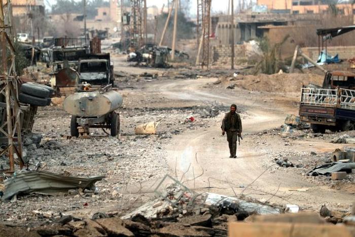 A fighter in a US-backed alliance battling the Islamic State group in eastern Syria walks near the village of Baghouz on January 27, 2019