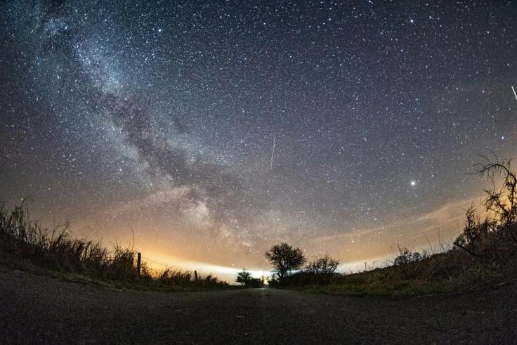 The milky way and meteors of the April Lyrids annual meteor shower in the night sky over the Baltic Sea