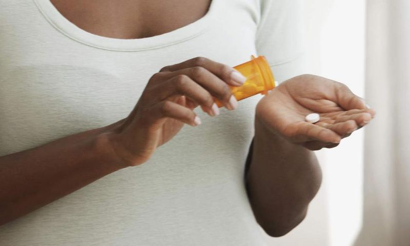 Woman taking meds (Courtesy)