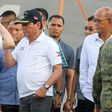 Philippine President Rodrigo Duterte (C) returns a salute from a Chinese naval officer as Philippine Defence Secretary Delfin Lorenzana (R) looks on during Duterte's visit to the Chinese warship Chang Chun in Davao on May 1, 2017