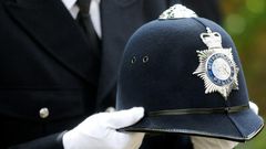 A police officer carries the helmet of Keith Palmer, the police officer killed in the March 22 Westminster terror attack, as he walks behind the coffin in the funeral procession in central London