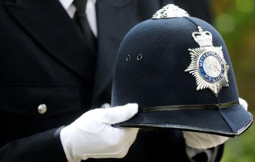 A police officer carries the helmet of Keith Palmer, the police officer killed in the March 22 Westminster terror attack, as he walks behind the coffin in the funeral procession in central London