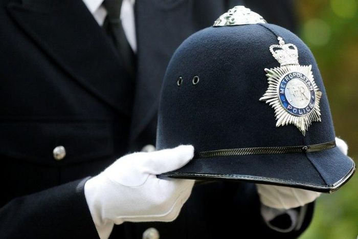 A police officer carries the helmet of Keith Palmer, the police officer killed in the March 22 Westminster terror attack, as he walks behind the coffin in the funeral procession in central London