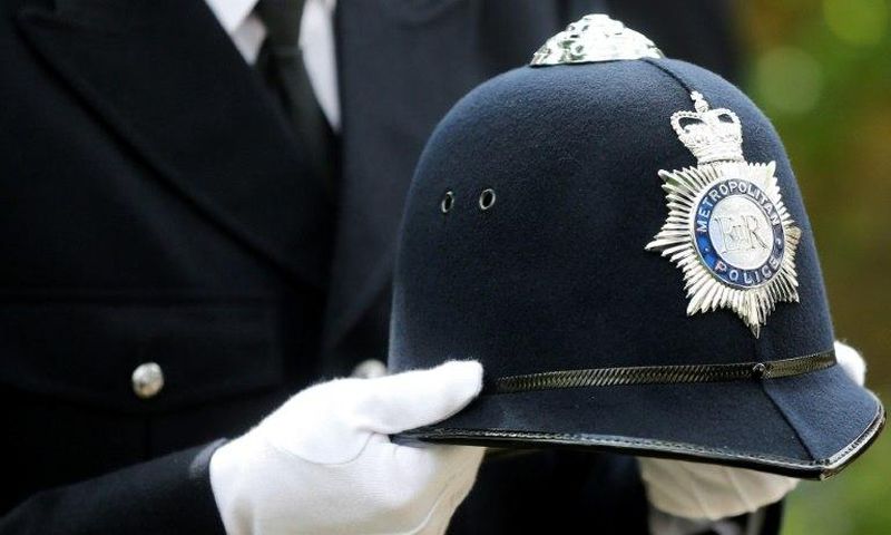 A police officer carries the helmet of Keith Palmer, the police officer killed in the March 22 Westminster terror attack, as he walks behind the coffin in the funeral procession in central London