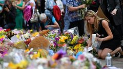 People lay flowers in tribute to the victims of the May 22 bomb attack in Manchester in northern England