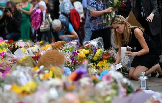 People lay flowers in tribute to the victims of the May 22 bomb attack in Manchester in northern England