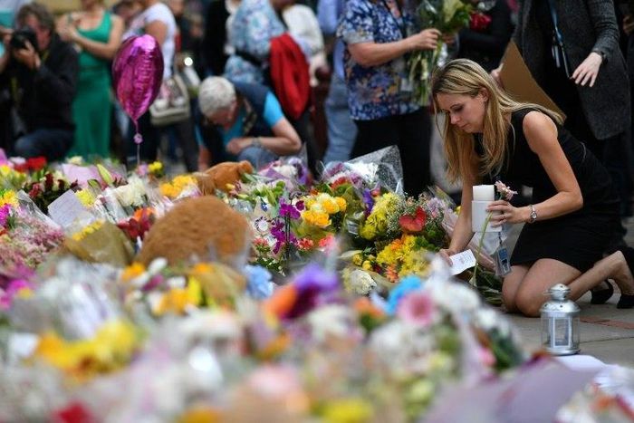 People lay flowers in tribute to the victims of the May 22 bomb attack in Manchester in northern England