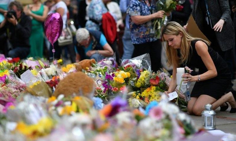 People lay flowers in tribute to the victims of the May 22 bomb attack in Manchester in northern England