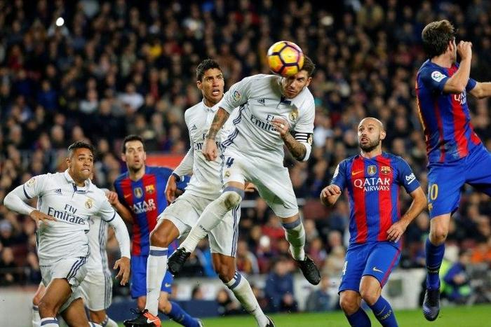 Real Madrid's Sergio Ramos (C) heads a ball to score the equalizer during the match against Barcelona at the Camp Nou stadium