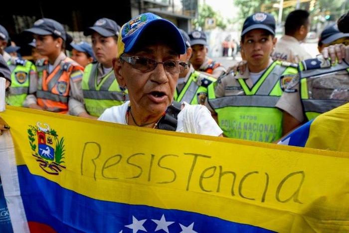 An opposition supporter holds a Venezuela's national flag as she marches protesting against the government of President Nicolas Maduro, in Caracas, on November 10, 2016