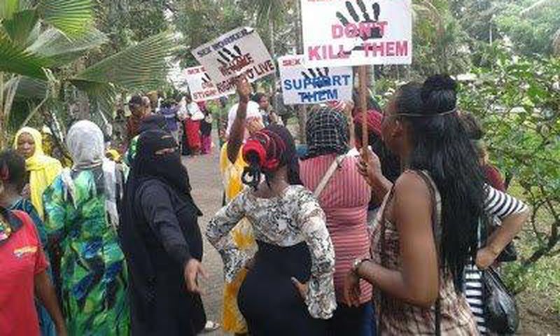 Kenyans prostitutes hold placards in protest over the murder of their colleague.