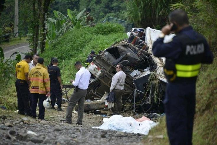 Policemen and rescue officials check the site where a bus plunged off a steep road killing 11 and injuring 12 in Heredia, Vara Blanca, Costa Rica on October 20, 2016