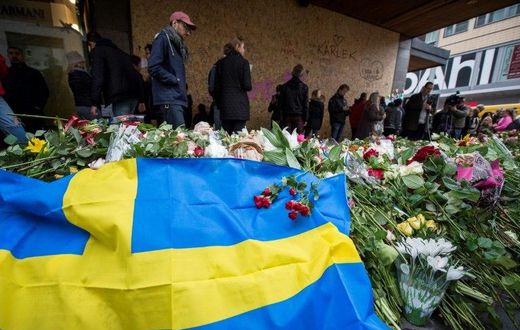 People gather at a makeshift memorial to commemorate the victims of Friday's terror attack near the site where a truck drove into Ahlens department store in Stockholm, Sweden, on April 10, 2017