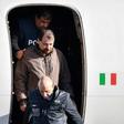 An Italian-flagged Falcon 900 plane carrying Battisti landed at Rome's Ciampino airport on Monday morning. Battisti, who was not wearing handcuffs, smiled grimly as he was escorted off the plane by a dozen police