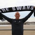 Swansea City's new US manager Bob Bradley poses for photographs with a Swansea scarf on the beach in Swansea, south wales