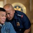 Philippine President Rodrigo Duterte (L) talks to Philippine National Police (PNP) Director General Ronald Dela Rosa (R) during a press conference in Manila on January 30, 2017