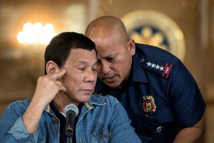 Philippine President Rodrigo Duterte (L) talks to Philippine National Police (PNP) Director General Ronald Dela Rosa (R) during a press conference in Manila on January 30, 2017