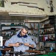 Syrian Abboud Jan repairs a disassembled rifle in his firearm-repair workshop in northeastern Syria's Hasakeh city