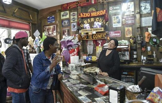 Migrants from Senegal and Niger joke with the waitress in the main bar of Sant' Alessio in Aspromonte, a small village of 330 inhabitants in Calabria, southern Italy