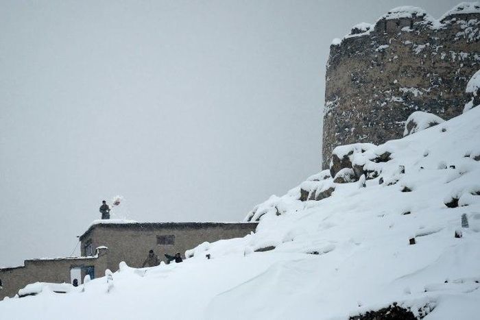 A Kabul resident shovels snow from a roof of his home after a major snowfall in the Afghan capital on February 5, 2017